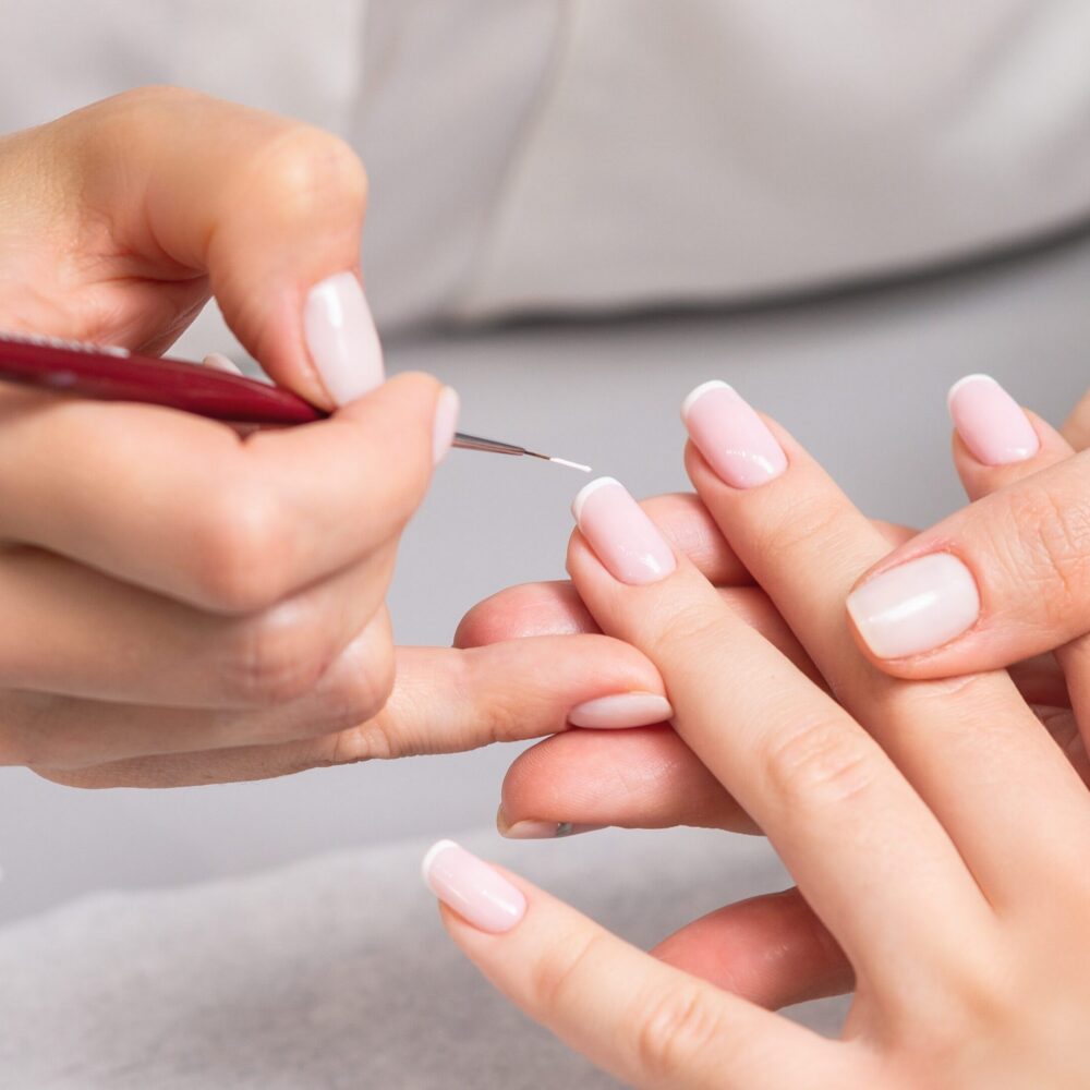 Nail artist painting nails with brush
