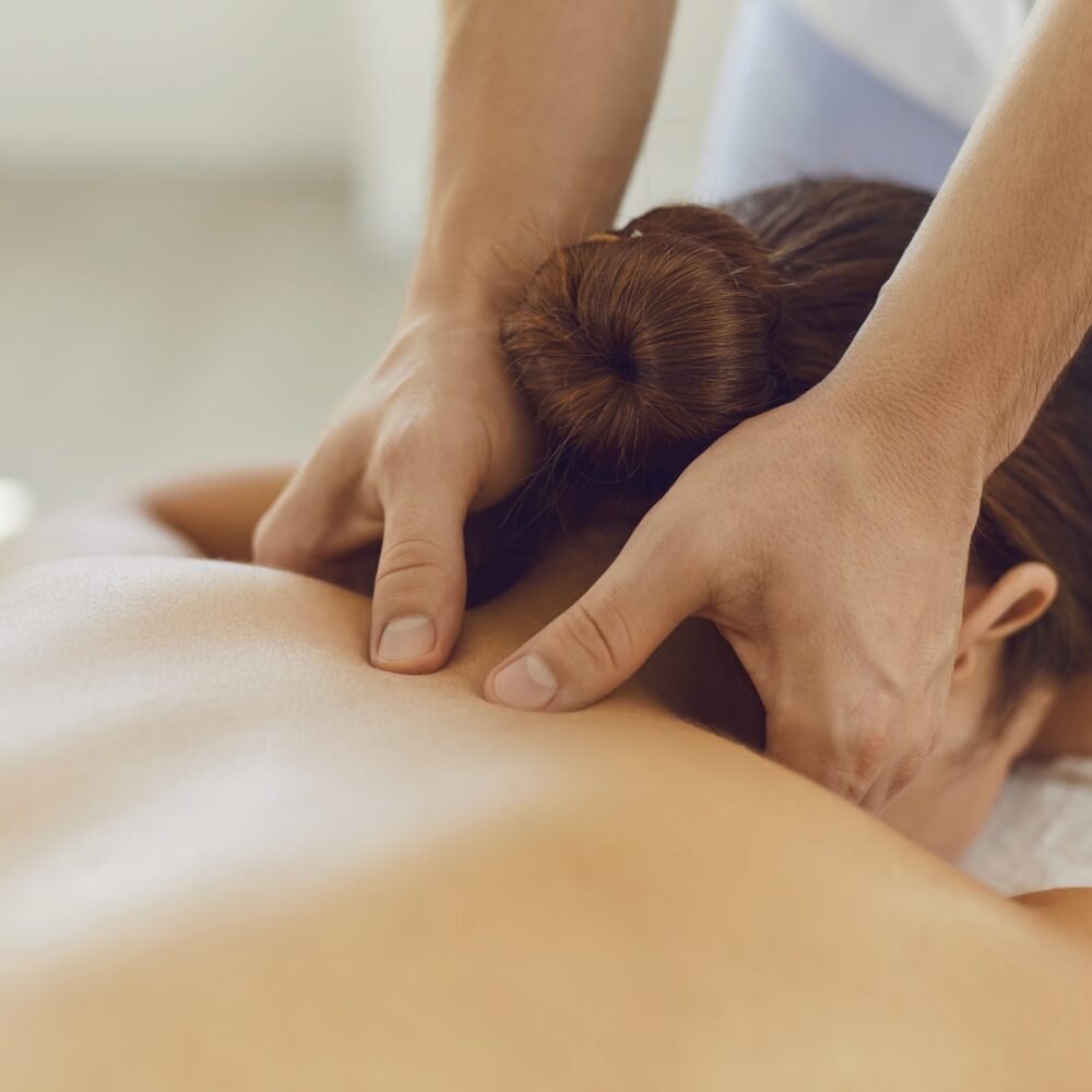 Hands giving therapeutic back massage