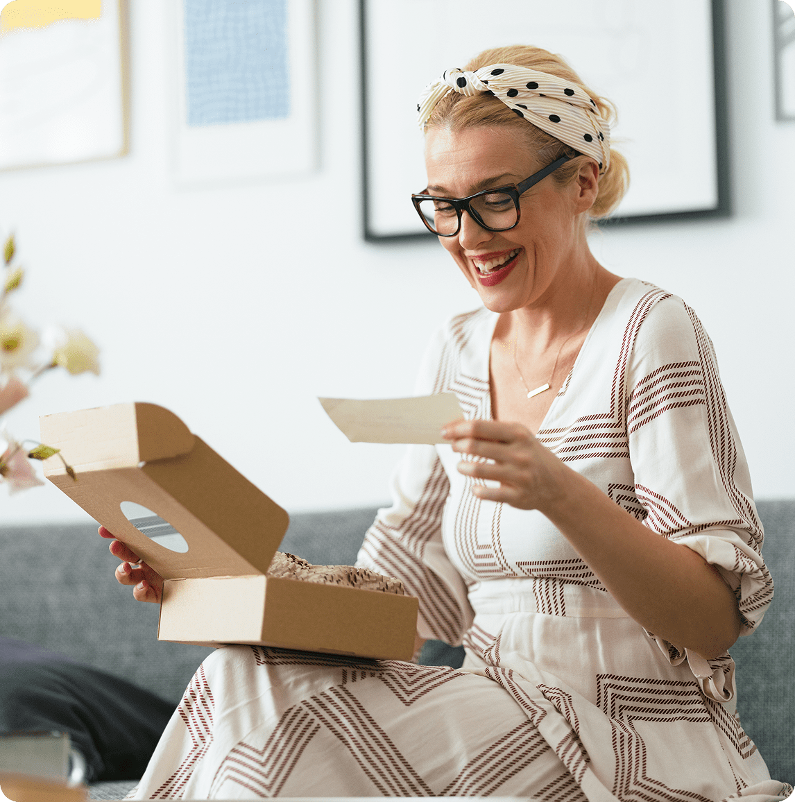 Happy woman reading a card at home