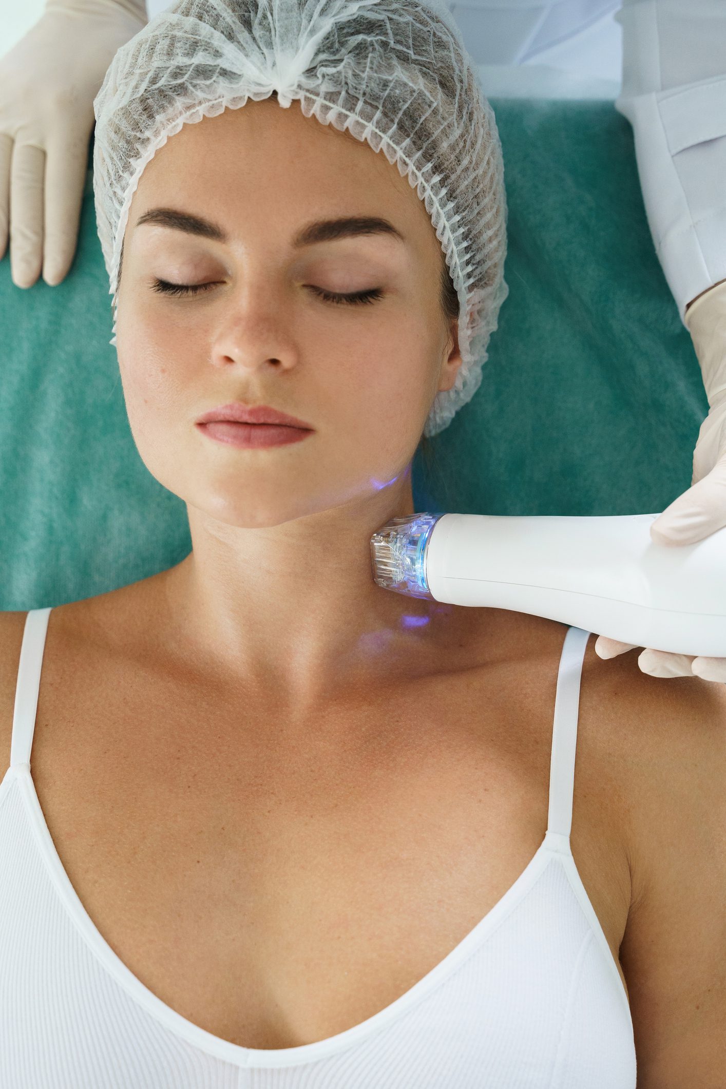 Beautiful woman during radiofrequency lifting treatment on her neck in a medical aesthetic clinic